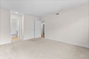 Thumbnail 7 of 40 - an empty living room with white walls and a carpeted floor