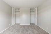 Thumbnail 7 of 22 - an empty bedroom with two closets and a carpeted floor