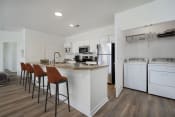 Thumbnail 5 of 30 - a kitchen with white appliances and a counter with stools