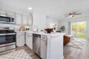 Thumbnail 2 of 35 - a white kitchen with a large island and stainless steel appliances