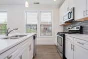 Thumbnail 17 of 40 - a kitchen with white cabinets and stainless steel appliances