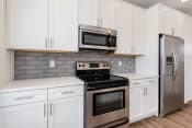 Thumbnail 16 of 40 - a kitchen with white cabinets and stainless steel appliances