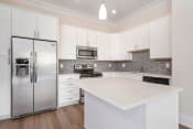 Thumbnail 2 of 40 - a kitchen with white cabinets and stainless steel appliances