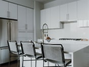 Thumbnail 10 of 43 - a white kitchen with white cabinets and a white table