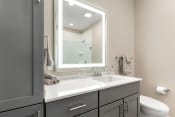 Thumbnail 10 of 82 - a bathroom with gray cabinets and a white sink
