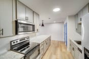 Thumbnail 4 of 14 - a kitchen with white cabinets and stainless steel appliances