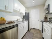 Thumbnail 6 of 35 - a kitchen with white cabinets and a black refrigerator