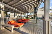Thumbnail 11 of 24 - poolside covered patio with lounge chairs and TV at Retreat at Brightside Apartments in Baton Rouge, LA