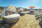 Thumbnail 14 of 47 - a patio with chairs and umbrellas at the enclave at woodbridge apartments in sugar land