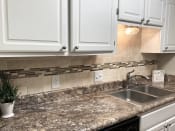Thumbnail 5 of 32 - White kitchen cabinets and granite countertops at Malibu at Martin Apartments in Huntsville, Alabama