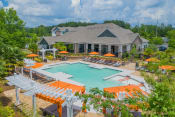Thumbnail 1 of 21 - a swimming pool with orange umbrellas in front of a house