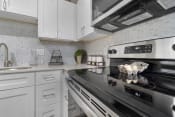 Thumbnail 6 of 60 - Kitchen with Stainless Steel appliances and custom white cabinets with soft close doors and white marble countertops