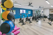 Thumbnail 14 of 39 - a fitness room with exercise bikes and a tv on the wall