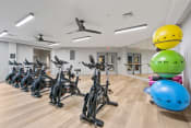 Thumbnail 13 of 39 - a fitness room filled with exercise bikes and helmets