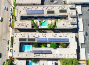 Thumbnail 28 of 28 - Aerial drone image of Sherman Oaks Gardens, showing solar panels and energy-efficient white roof.
