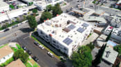 Thumbnail 26 of 27 - Aerial drone photo of Magnolia Terrace showing solar panels and energy-efficient white roof.