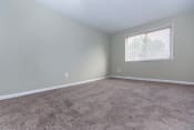 Thumbnail 6 of 10 - an empty bedroom with a large window and carpet at Highland Ridge, Capitol Heights, 20743