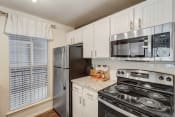 Thumbnail 7 of 44 - an updated kitchen with stainless steel appliances and white cabinets