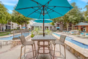 Thumbnail 29 of 44 - a patio with tables and umbrellas next to a swimming pool