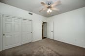 Thumbnail 16 of 27 - Large carpeted bedroom with sliding door closet and ceiling fan