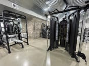 Thumbnail 21 of 63 - a gym with weights machines and other equipment in a building with galvanized ceilings