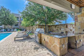 Thumbnail 88 of 94 - an outdoor kitchen with a grill and a swimming pool at Discovery at Craig Ranch, Texas, 75070