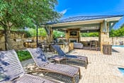Thumbnail 82 of 94 - a covered patio with chairs and a grill next to a pool at Discovery at Craig Ranch, McKinney, TX
