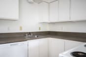 Thumbnail 11 of 22 - an empty kitchen with white appliances and white cabinets