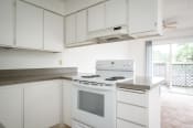 Thumbnail 10 of 22 - an empty kitchen with white appliances and white cabinets