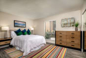 Thumbnail 5 of 28 - One Bedroom Apartments in Oceanside CA - Stone Arbor - Bedroom with Wood-Style Flooring, Mirrored Closets, and Large Window