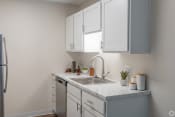 Thumbnail 6 of 19 - a kitchen with white cabinets and a stainless steel sink