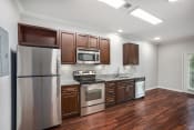 Thumbnail 52 of 67 - a kitchen with wooden cabinets and stainless steel appliances