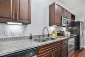 Thumbnail 45 of 67 - a kitchen with wood cabinets and granite countertops