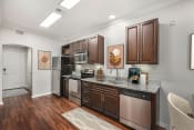Thumbnail 46 of 67 - a kitchen with dark wood cabinets and granite countertops