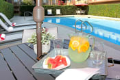 Thumbnail 16 of 18 - Apartments for Rent West Covina CA - Tuscany Villas - Pool Area with Tables, Lounge Chairs, and Umbrellas