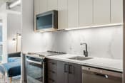 Thumbnail 4 of 17 - a kitchen in a 555 waverly unit with a sink and stove and a microwave above