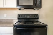 Thumbnail 7 of 14 - stovetop and microwave in kitchen at North Washington Apartments