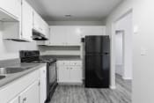 Thumbnail 17 of 17 - a kitchen with white cabinets and black appliances at Jacksonville Heights Apartments