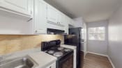 Thumbnail 10 of 28 - a kitchen with white cabinets and a black stove top oven