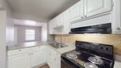Thumbnail 4 of 28 - a kitchen with white cabinets and a black stove top oven