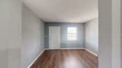 Thumbnail 19 of 28 - an empty room with hardwood floors and a white door