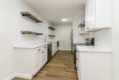 Thumbnail 10 of 15 - a kitchen with white cabinetry and a wood floor