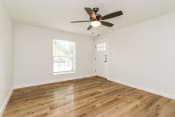 Thumbnail 7 of 15 - a bedroom with hardwood floors and a ceiling fan