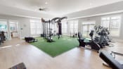 Thumbnail 18 of 31 - a home gym with a green rug and exercise equipment at The Retreat at Fuquay-Varina Apartments, Fuquay-Varina