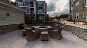 Thumbnail 26 of 31 - a patio with a fire pit and wicker furniture at The Retreat at Fuquay-Varina Apartments, Fuquay-Varina