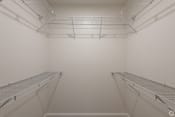 Thumbnail 30 of 32 - the walk in closet in a white room with two empty shelves