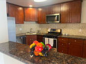 Thumbnail 5 of 33 - a kitchen with wooden cabinets and granite countertops
