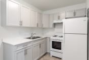 Thumbnail 7 of 17 - a white kitchen with white appliances and white cabinets