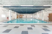 Thumbnail 12 of 18 - a large indoor swimming pool with white walls and ceilings and a checkered floor