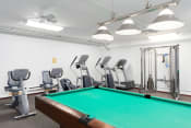 Thumbnail 24 of 26 - a room with a pool table and gym equipment
